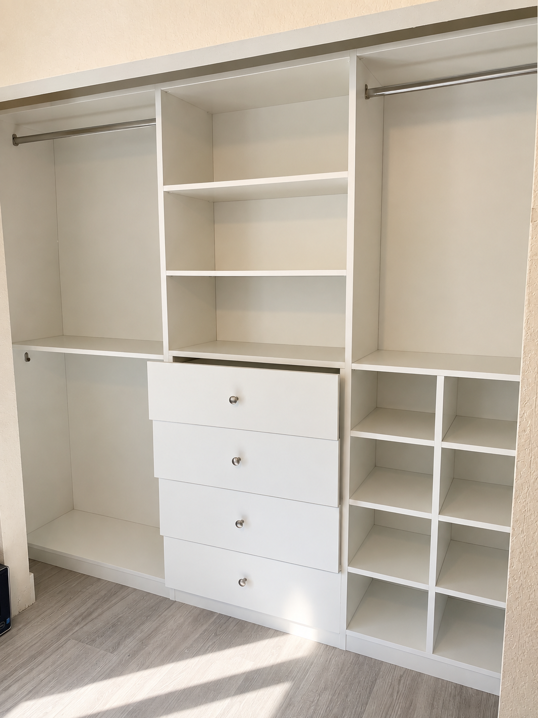 Open white closet with drawers, shelving, and dual hanging zones
