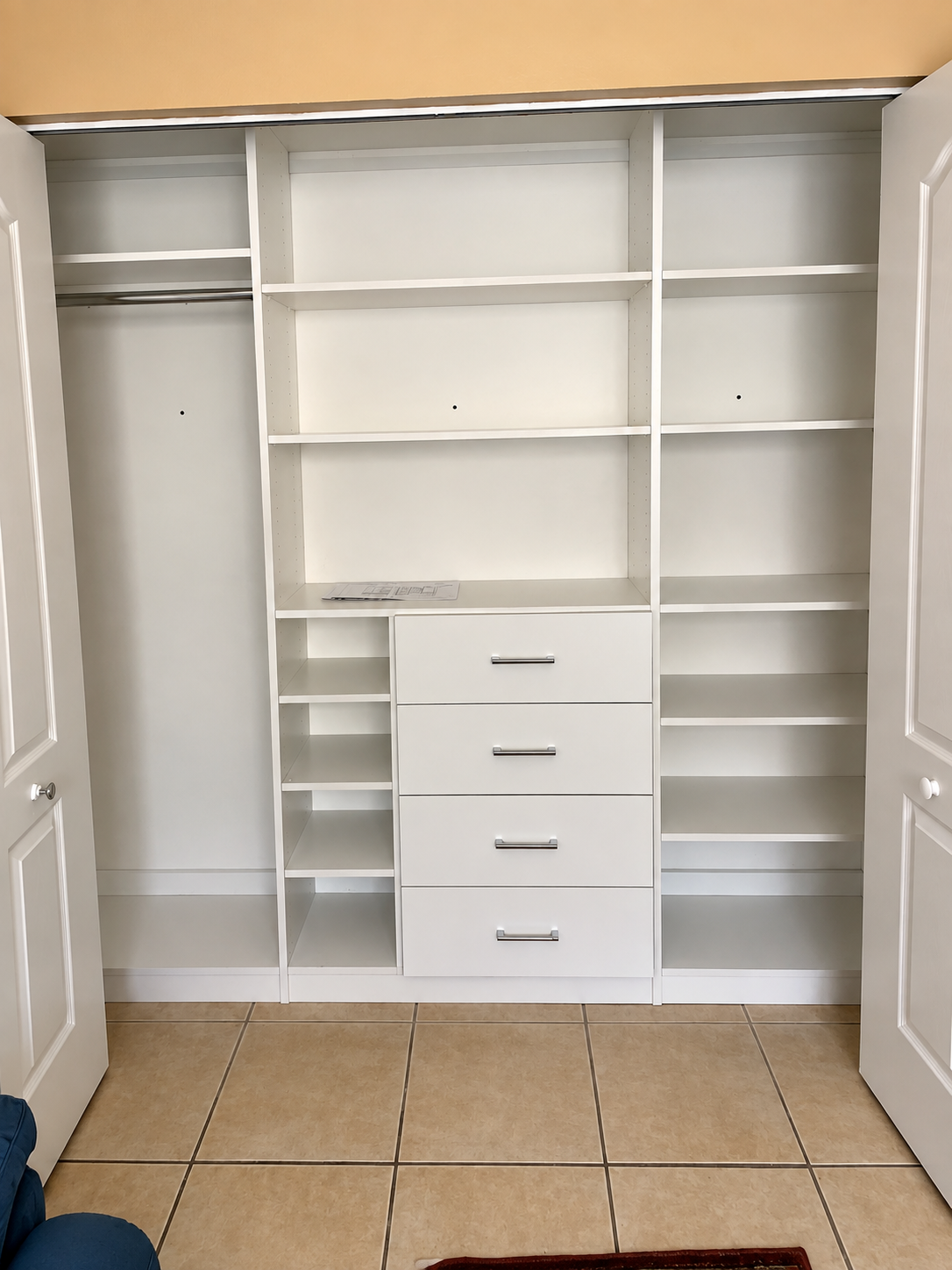 White reach-in closet with central drawers and adjustable shelving