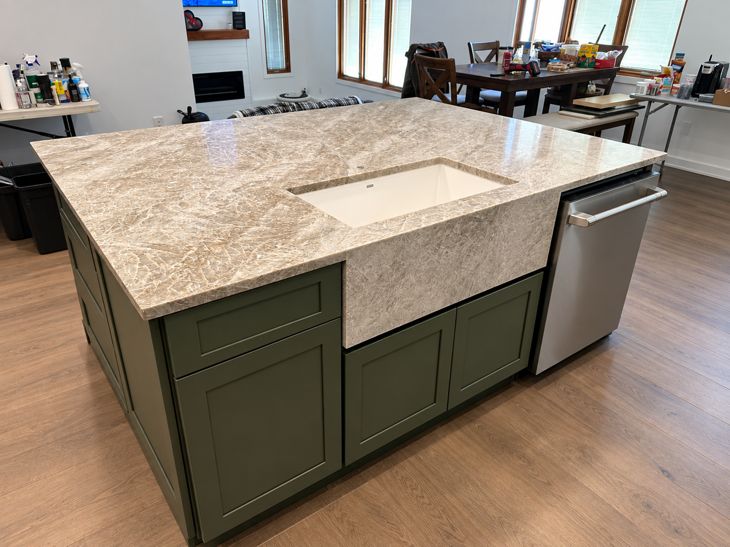 Olive green kitchen island wrapped in expressive stone