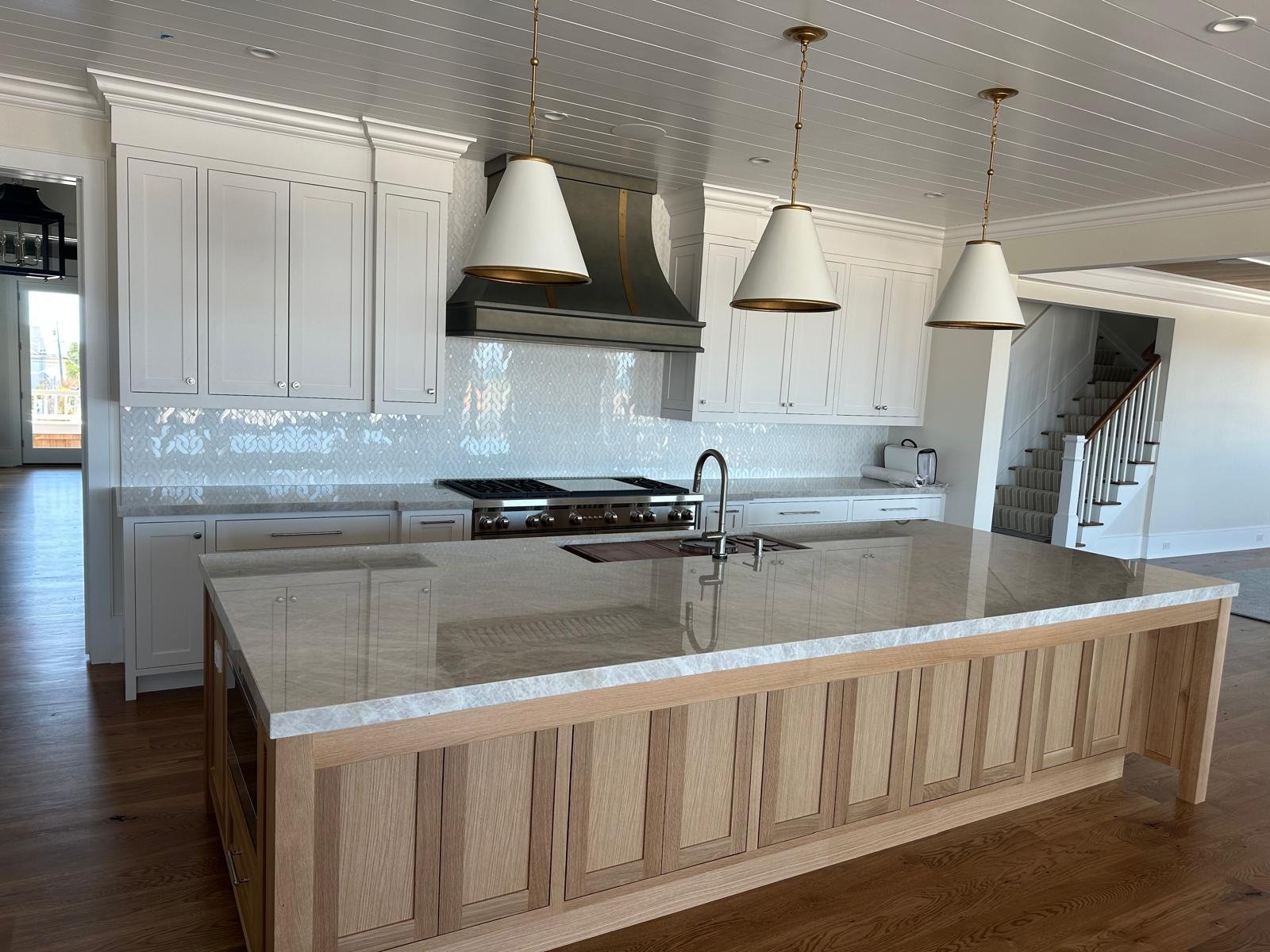 White custom kitchen with natural wood island and stone surface